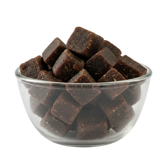 Palm jaggery cubes in a glass bowl on white